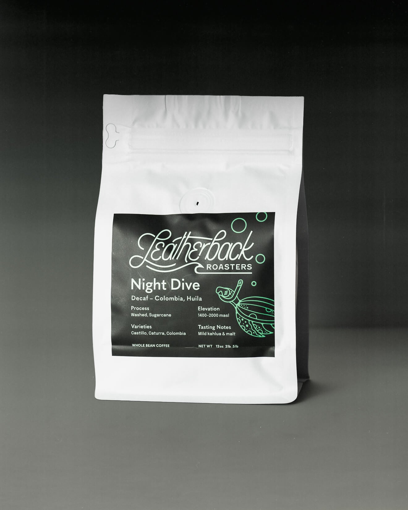 A white stand-up pouch of Leatherback Roasters 'Night Dive' Decaf coffee, featuring a black label with white and green text and graphics, set against a dark gray to black gradient background.
