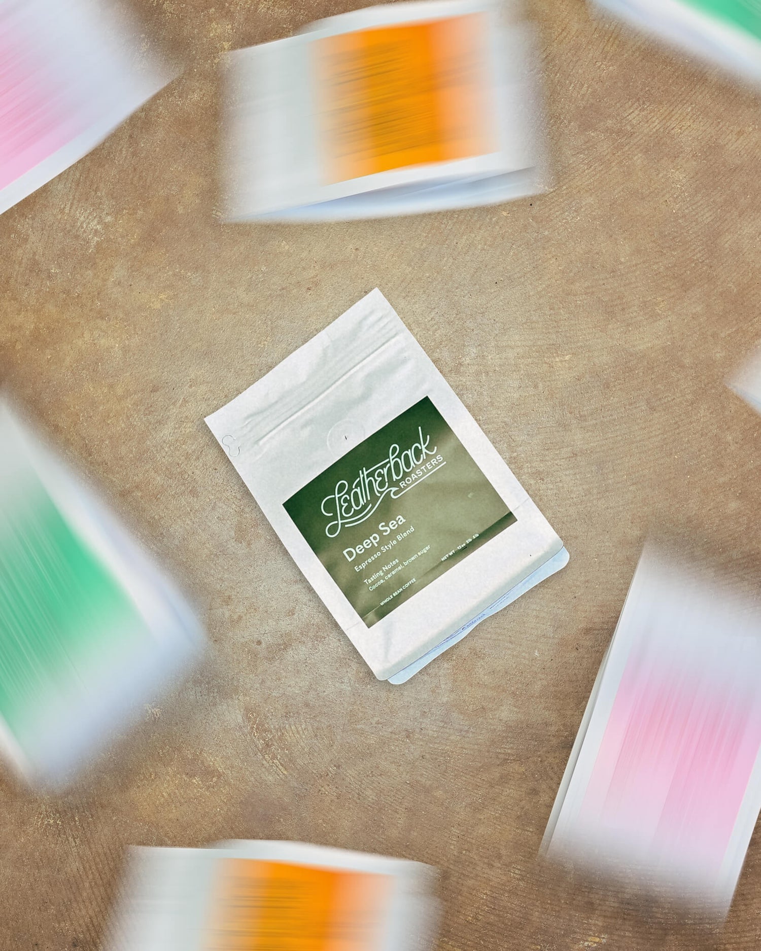 A white standup 12oz bag of Leatherback Roasters Deep Sea espresso blend, with blurry bags around it of other single origin and blends featured in the Roaster's Choice monthly rotation.