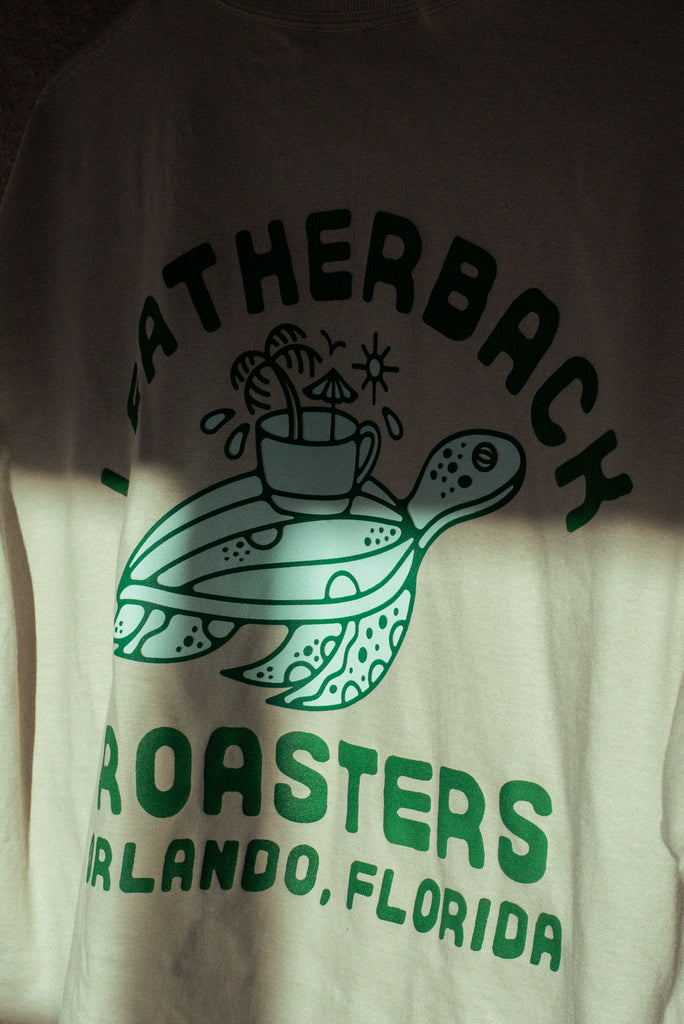 OG Tee back print. Leatherback Roasters Orlando, FL. Leatherback sea turtle carrying mug of coffee and sunshine